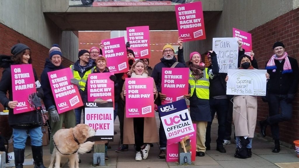 Sussex branch gather at the entrance to Falmer Quad during a 2023 strike. They hold strike banners. General Secretary Jo Grady joins them on the picket line.